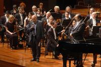 Enzo Restagno presenta il concerto della Philharmonia Orchestra e sulla destra il direttore Charles Dutoit